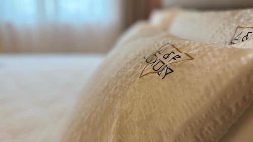 a white bed with two pillows on top of it at A&F LUXURY Rooms Pinzolo in Pinzolo