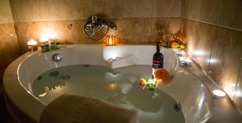 a bath tub with a bottle of wine in it at Drosia Hotel in Kato Loutraki