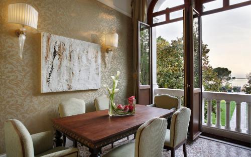 a dining room with a table and chairs and a window at San Clemente Palace Venice in Venice