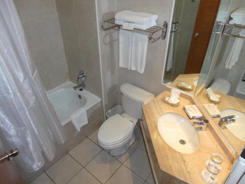 a bathroom with a sink and a toilet and a tub at Hotel Diego de Almagro Los Angeles in Los Ángeles