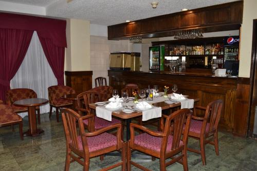 a dining room with a table and chairs and a bar at Hotel Diego de Almagro Los Angeles in Los Ángeles