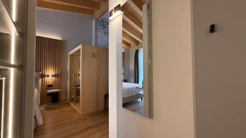 a room with a bed and a mirror on the wall at A&F LUXURY Rooms Pinzolo in Pinzolo