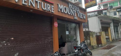 a store front of a store with a motorcycle parked outside at Hotel Mount view inn in Rishīkesh