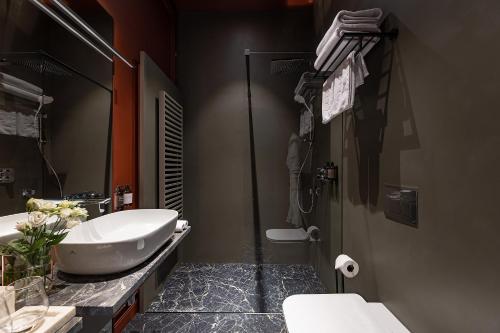 a bathroom with a sink and a toilet and a tub at LUBICH Concept Hotel in Lviv