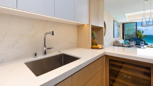 a kitchen with a large sink and a view of the ocean at ❤PiH❤ Hapuna Sunsets Beachfront Steps From Ocean A33 in Hapuna Beach