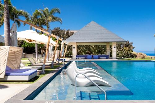 a swimming pool with lounge chairs and umbrellas at MAUNA KEA BEACH ESCAPE Luxurious home in private community with Heated Private Pool and Spa Detached Ohana Suite in Waimea
