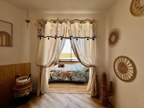 a bedroom with a window with a bed in it at Evasion cosy aux pieds de l'Océan in Lacanau