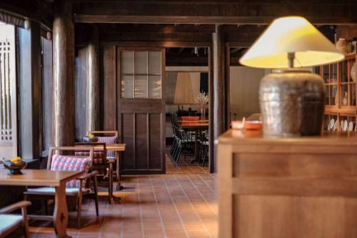 a restaurant with tables and chairs and a lamp at Lijiang Old Town Anyu hotel in Lijiang