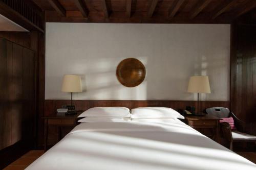 a large white bed with two tables and two lamps at Lijiang Old Town Anyu hotel in Lijiang
