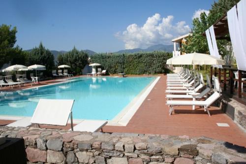 una piscina con lettini e ombrelloni di Salerno Mare e Luci Village Palinuro a Palinuro