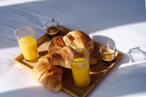 una bandeja de pan y dos vasos de jugo de naranja en L'Escale Royale Saint-Martin-la-Garenne Port Ilon - Seine - Giverny, en Saint-Martin-la-Garenne
