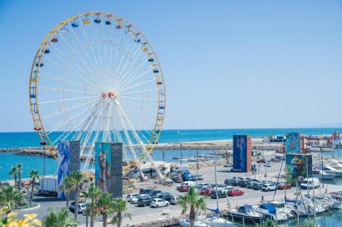a ferris wheel at the beach in a city at Le Prestigieux Accès direct Port et Plage in Le Barcarès
