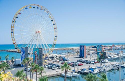 a ferris wheel in a marina next to a harbor at Le Prestigieux Accès direct Port et Plage in Le Barcarès