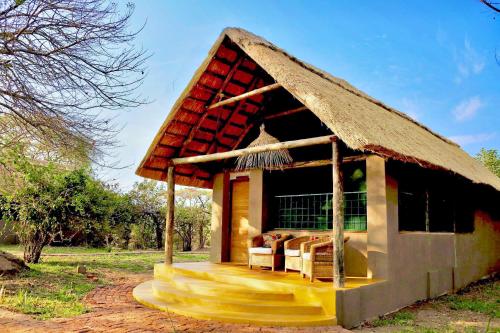 a small hut with a thatched roof on a field at Thornicroft Lodge - South Luangwa in Mpanda