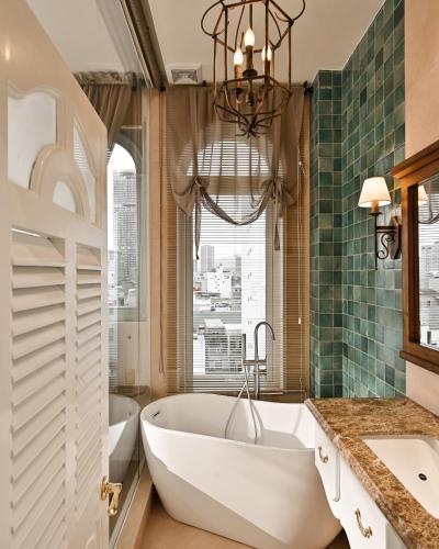 a bathroom with a large tub and a window at The Luna Boutique Hotel in Quy Nhon