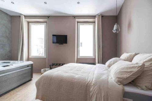La suite jacuzzi في مارسيليا: غرفة نوم بها سرير أبيض ونافذتان