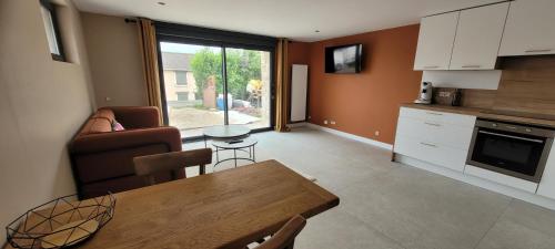 a kitchen and living room with a table and a couch at 2 Gites dans les remparts à Dun sur Meuse in Dun-sur-Meuse