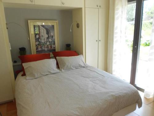 a bedroom with a bed with a red head board at Appartement charmant à Seillans avec piscine in Seillans