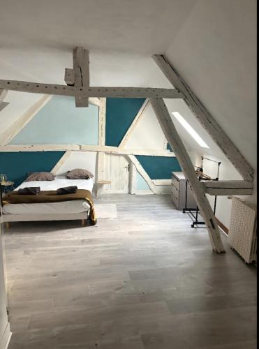 - une chambre mansardée avec un lit et des poutres apparentes dans l'établissement Maison à Troyes, à Troyes