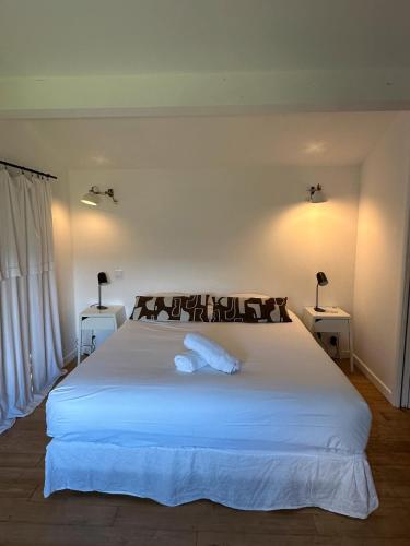 a bedroom with a large white bed with two tables at Chambres d'hote Bergerie A Maredda in Murato
