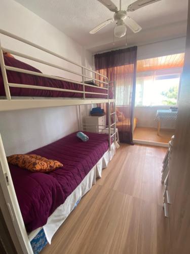 a bedroom with bunk beds with a purple bed at Playa Rompido in Huelva