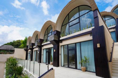 a facade of a building with large windows at Sunny Samudra in Uluwatu
