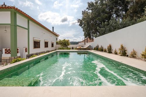 a swimming pool in the backyard of a house at Casa da Ti Maria Vieira in Santa Clara-a-Velha