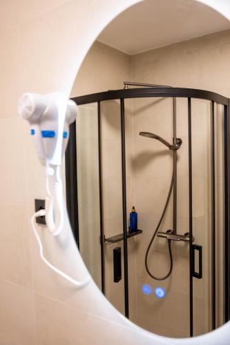 a bathroom with a shower with a blow dryer at Rooms Villa Padre in Pag