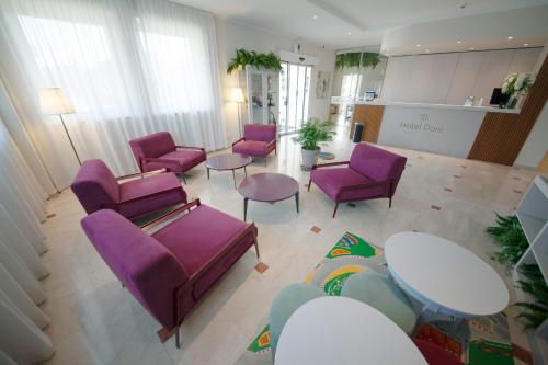 a living room with purple chairs and tables at Hotel Dorè in Castelnuovo del Garda