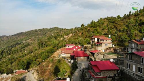 a village on a hill with houses on it at Indus Valley Homestay in Mukteswar