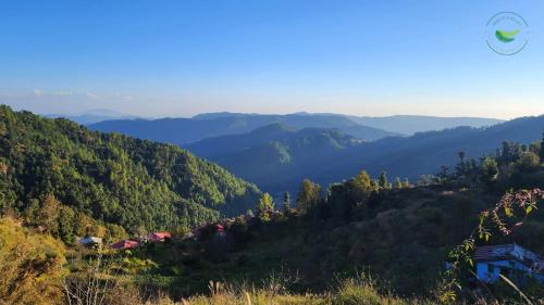 a view of a valley with mountains in the distance at Indus Valley Homestay in Mukteswar