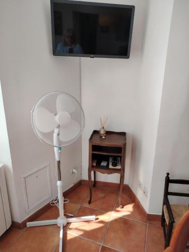 Cette chambre dispose d'un ventilateur et d'une télévision murale. dans l'établissement Chez Adèle, au Mont-Saint-Michel