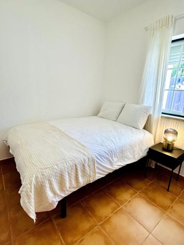 a white bed in a room with a window at Casa Martins Country Apt 3 - Private parking & WiFi in Freiria