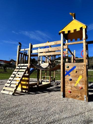 a wooden playground with a slide and a play structure at Casa Martins Country Apt 3 - Private parking & WiFi in Freiria