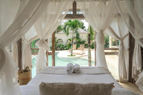 a bedroom with a bed with two slippers on it at Uluwatu Lagoons - Retreat and Villas in Uluwatu