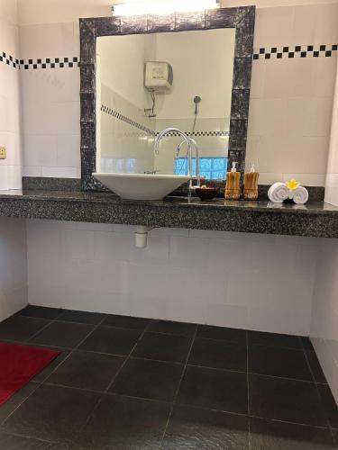 a bathroom with a sink and a mirror at Rumah Tenun in Karangasem