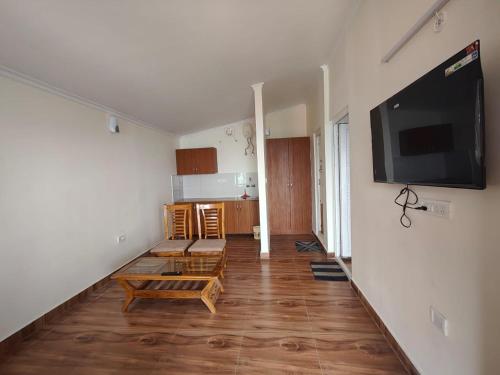 a living room with a large flat screen tv on the wall at Indus Valley Homestay in Mukteswar