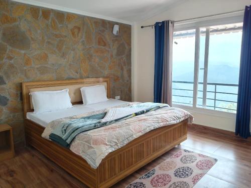 a bedroom with a bed with a stone wall at Indus Valley Homestay in Mukteswar
