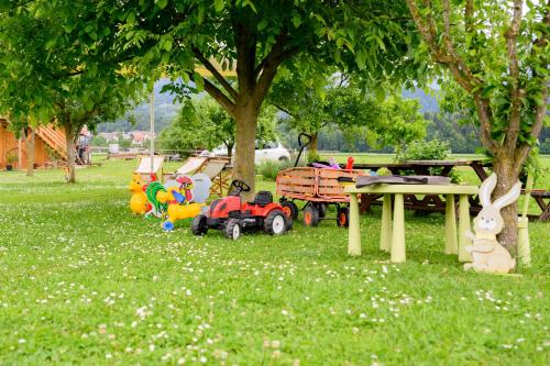 a group of toys sitting in the grass under a tree at GLAMPING HOUSE RANČ LUŽE in Luže