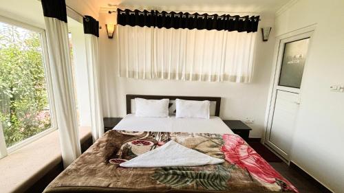 a bedroom with a bed and a window at Indus Valley Homestay in Mukteswar