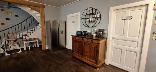 a kitchen with a counter and a refrigerator and a door at Grand gite familial 5 chambres à Ally, dans le Cantal à côté de Salers in Ally