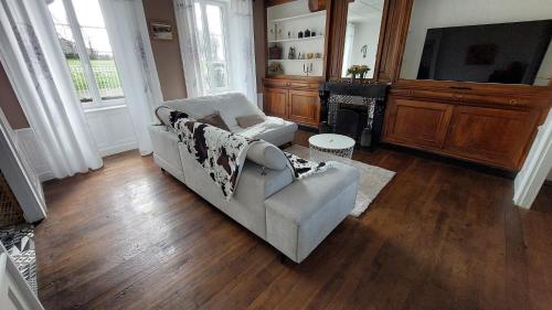 a living room with a couch and a television at Grand gite familial 5 chambres à Ally, dans le Cantal à côté de Salers in Ally