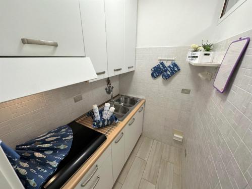 Una pequeña cocina con fregadero y encimera. en Residence Alisei, en Lignano Sabbiadoro