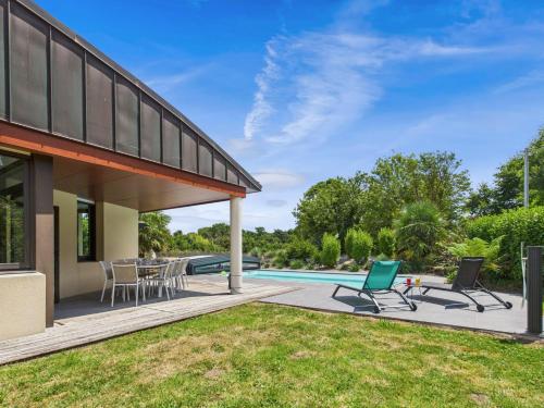 un patio extérieur avec des chaises et une piscine dans l'établissement Jardin et piscine - 1km de la plage de Mousterlin, à Fouesnant