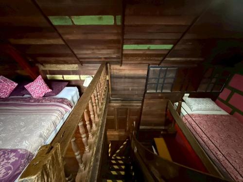 two beds in a room with wooden walls at tamarind guesthouse in Phra Nakhon Si Ayutthaya