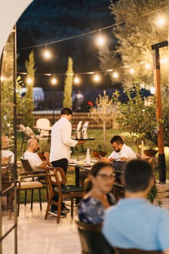 a man serving food at an outdoor restaurant at night at CAROLEA VILLAS in Ulcinj