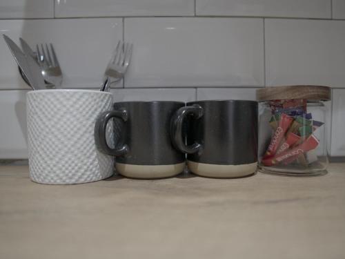 three black coffee mugs sitting on a kitchen counter at Insolam Accommodation in Mokopane