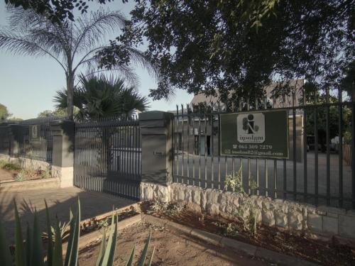 a fence with a sign in front of a building at Insolam Accommodation in Mokopane