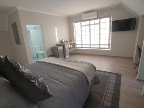 a bedroom with a large bed and a bathroom at Insolam Accommodation in Mokopane
