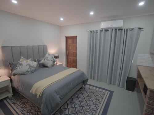a bedroom with a bed and a window with curtains at Insolam Accommodation in Mokopane